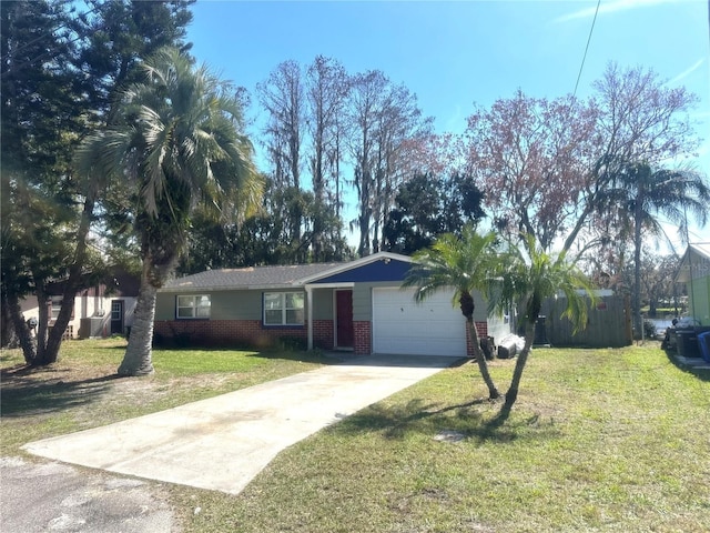 ranch-style home featuring concrete driveway, a front lawn, an attached garage, and brick siding