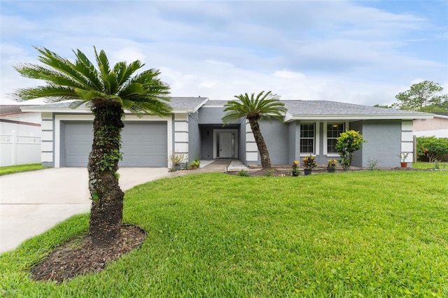 view of front of home with an attached garage, stucco siding, concrete driveway, and a front yard