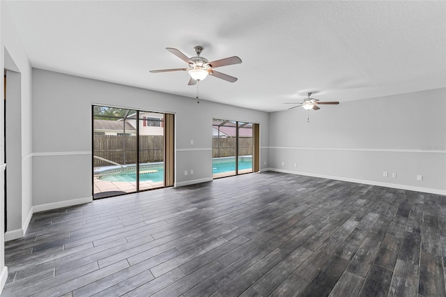 spare room with a ceiling fan, a textured ceiling, baseboards, and dark wood-type flooring