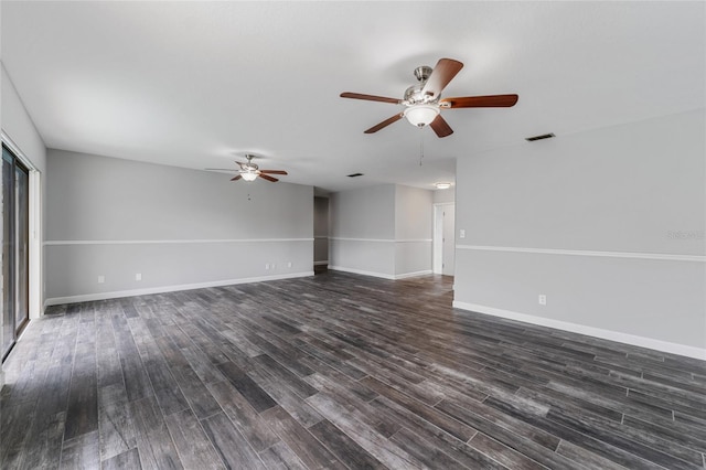 empty room with ceiling fan, dark wood-style flooring, visible vents, and baseboards