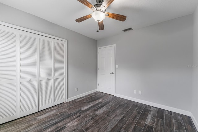 unfurnished bedroom with baseboards, visible vents, a ceiling fan, dark wood finished floors, and a closet