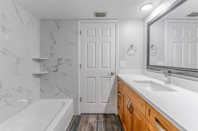 bathroom with vanity, shower / bathing tub combination, wood finished floors, and visible vents