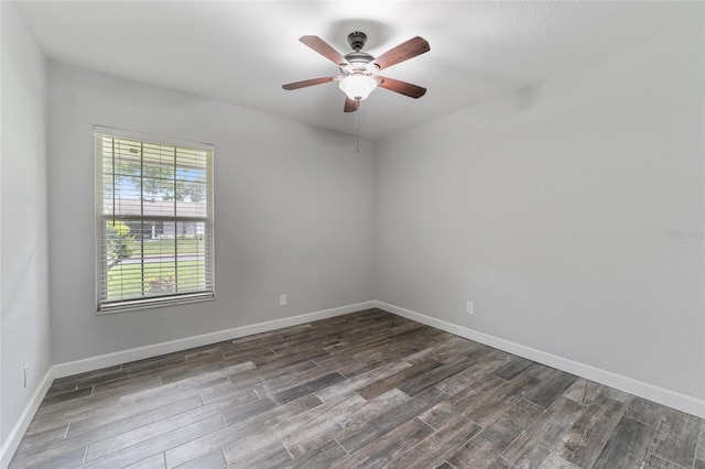 spare room featuring dark wood-style floors, baseboards, and a ceiling fan