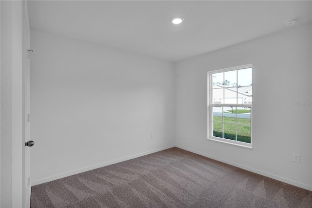 unfurnished room featuring carpet floors and baseboards