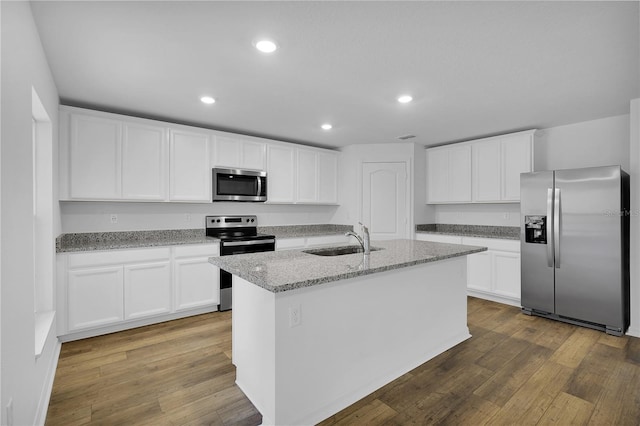 kitchen with recessed lighting, a sink, white cabinets, appliances with stainless steel finishes, and wood-type flooring