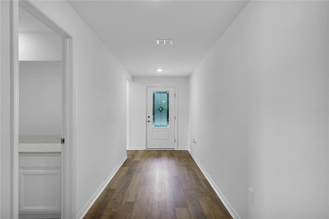 entryway with dark wood finished floors, visible vents, and baseboards