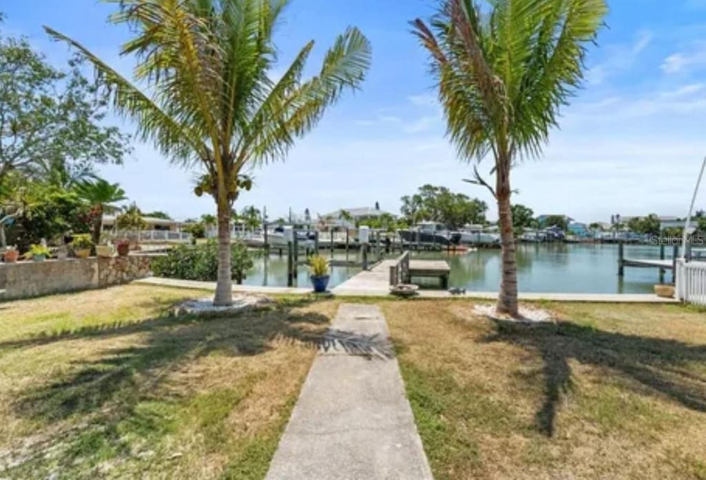 dock area with a water view and a lawn