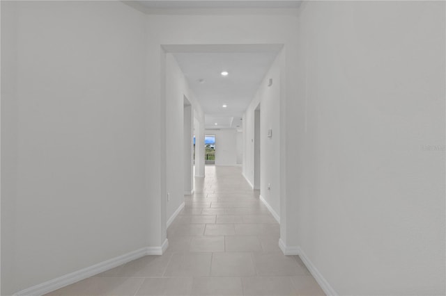 corridor featuring recessed lighting, light tile patterned flooring, and baseboards