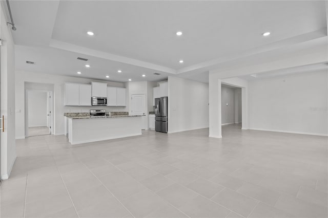 unfurnished living room with recessed lighting, baseboards, visible vents, and a tray ceiling