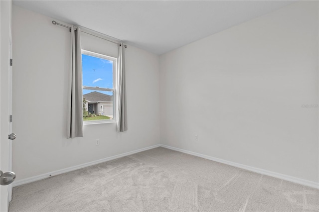 carpeted empty room with baseboards