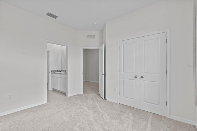 unfurnished bedroom with light carpet, baseboards, visible vents, and a closet