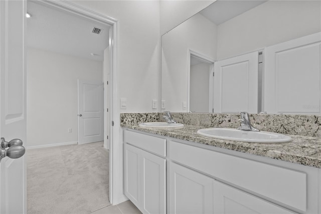 full bath with visible vents, a sink, baseboards, and double vanity