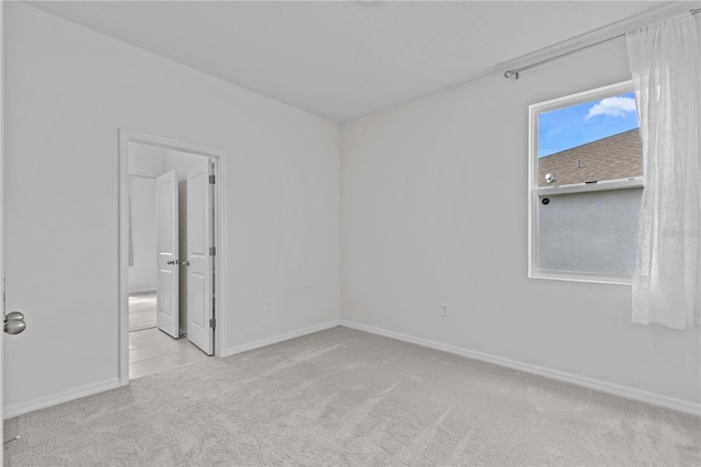 empty room featuring carpet floors and baseboards