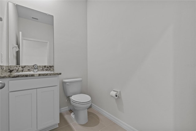 half bath featuring tile patterned flooring, toilet, visible vents, vanity, and baseboards