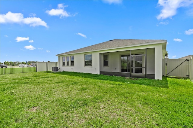 rear view of property with a gate, a yard, fence, and central AC unit