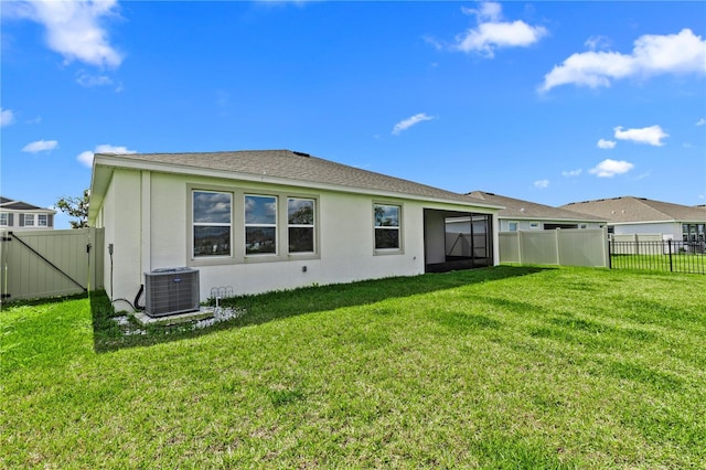 back of house featuring a lawn, stucco siding, cooling unit, and a fenced backyard