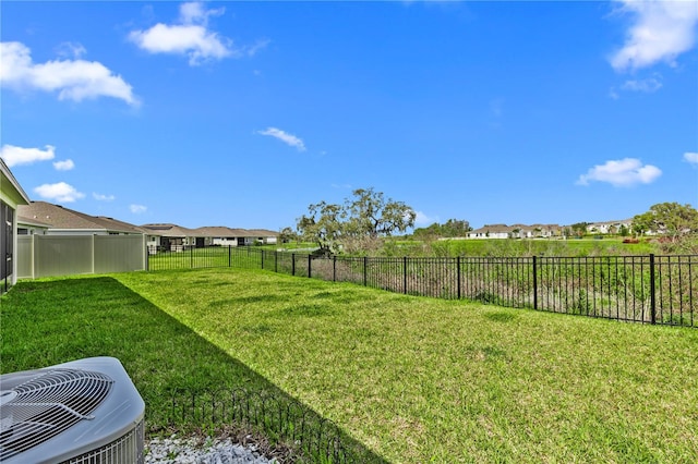 view of yard featuring a residential view, fence, and central air condition unit