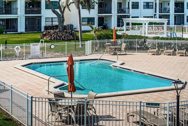 community pool with a patio area, fence, and a pergola