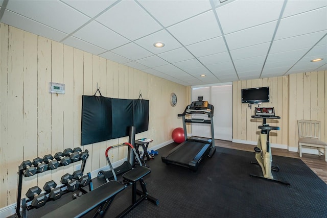 exercise room featuring recessed lighting, a drop ceiling, and baseboards