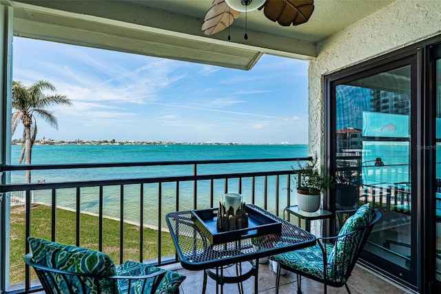 balcony with a water view and a ceiling fan