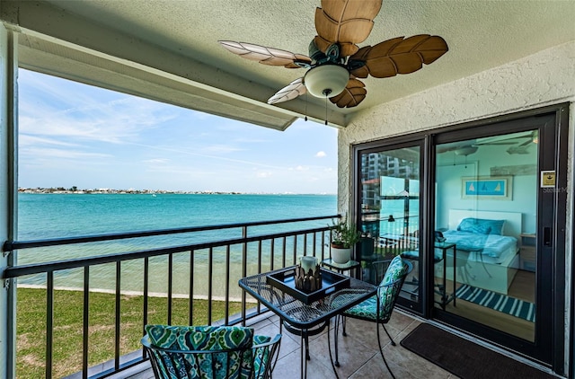 balcony featuring a water view and ceiling fan