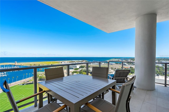 balcony with a water view and outdoor dining space