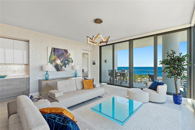 living area with a water view, an inviting chandelier, and floor to ceiling windows