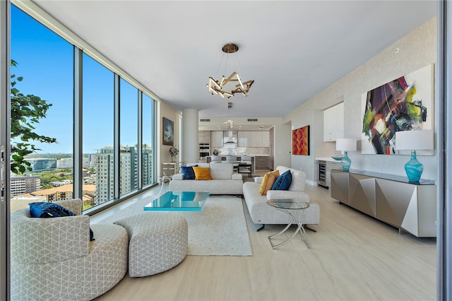 living room featuring beverage cooler, a chandelier, and a wall of windows