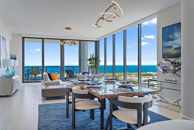 dining area featuring light tile patterned floors, expansive windows, a water view, and an inviting chandelier