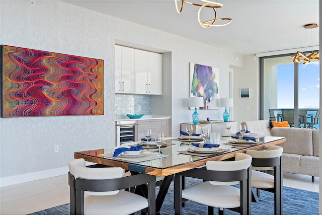 dining space featuring wallpapered walls, baseboards, wine cooler, an inviting chandelier, and floor to ceiling windows