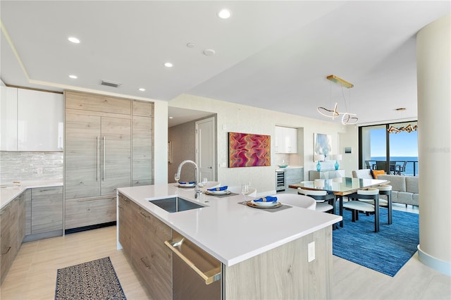 kitchen with dishwasher, modern cabinets, visible vents, and a sink