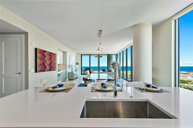 kitchen featuring a wealth of natural light, a wall of windows, a sink, and light countertops