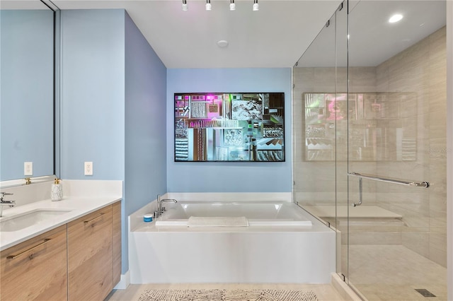 bathroom with a stall shower, vanity, and a bath