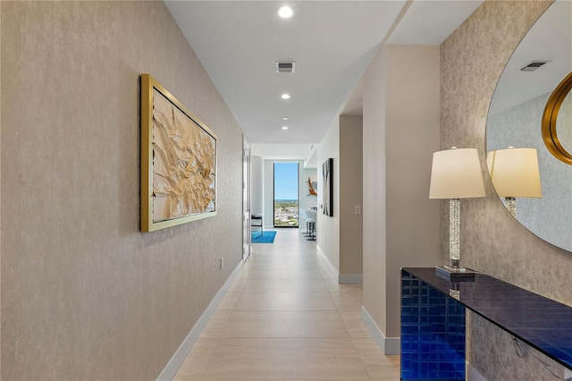 corridor with baseboards, light tile patterned floors, visible vents, and recessed lighting