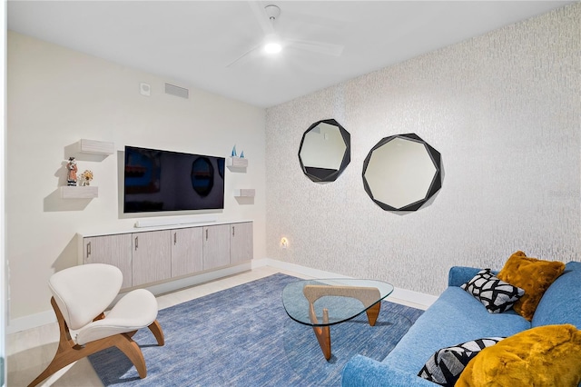 living room featuring an accent wall, visible vents, and baseboards