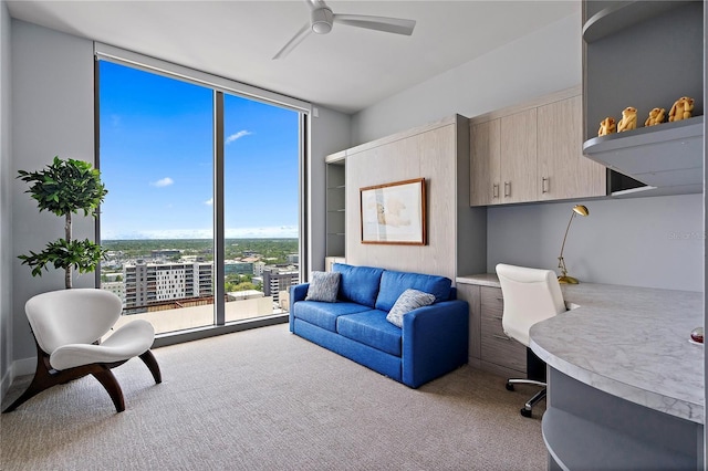 interior space with expansive windows, carpet flooring, and a ceiling fan