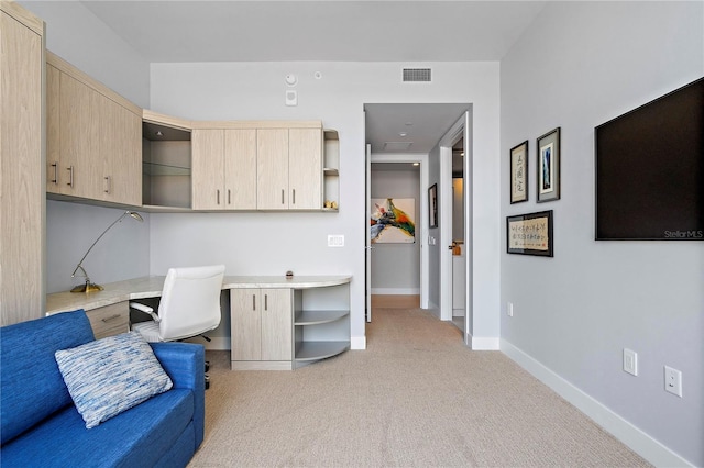 office space featuring baseboards, visible vents, light colored carpet, and built in study area