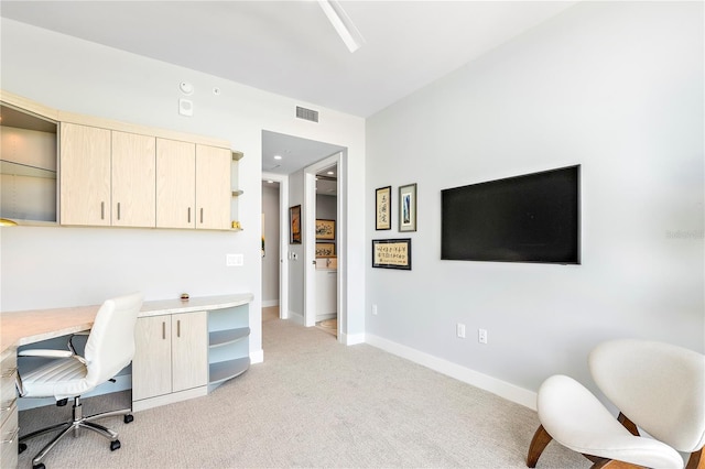 office space with baseboards, visible vents, and light colored carpet