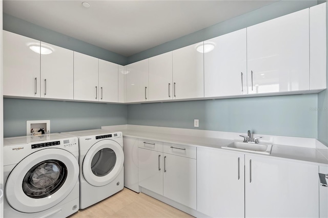 laundry area with cabinet space, a sink, and washer and clothes dryer