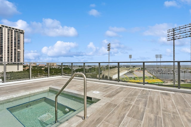 view of swimming pool with a water view and a hot tub