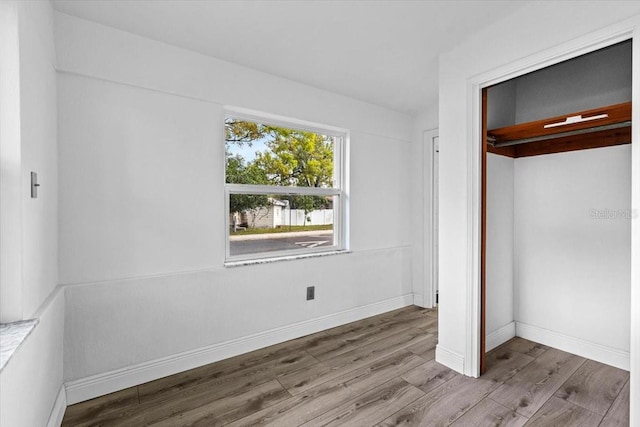 unfurnished bedroom featuring wood finished floors and baseboards