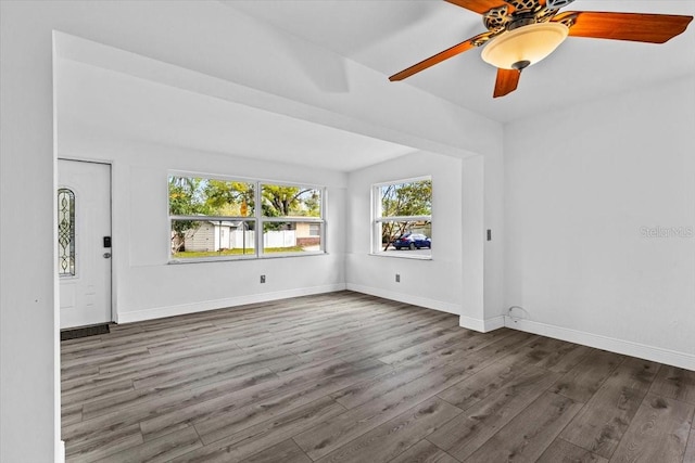 spare room with a ceiling fan, baseboards, and wood finished floors