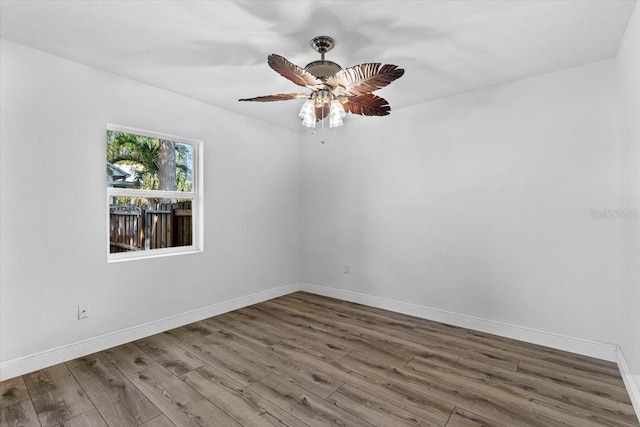 spare room featuring a ceiling fan, baseboards, and wood finished floors