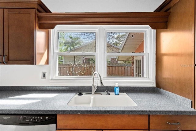 kitchen with a sink, dark countertops, brown cabinetry, and dishwasher