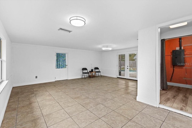 spare room with light tile patterned floors, visible vents, electric panel, and baseboards