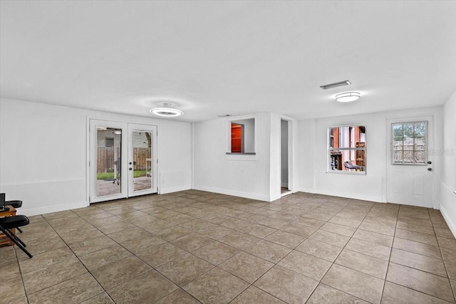 empty room with french doors, visible vents, baseboards, and tile patterned floors