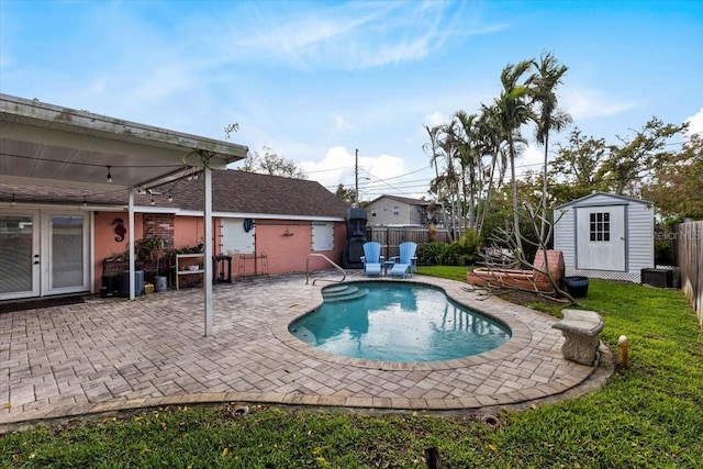 view of pool with a storage shed, a fenced in pool, a fenced backyard, an outdoor structure, and a patio area