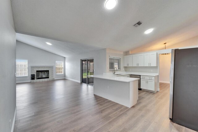 kitchen featuring stainless steel appliances, light countertops, visible vents, a sink, and a peninsula