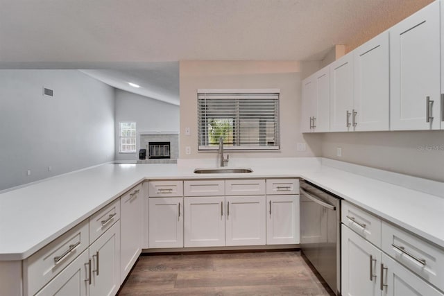 kitchen featuring light countertops, visible vents, white cabinets, a sink, and dishwasher