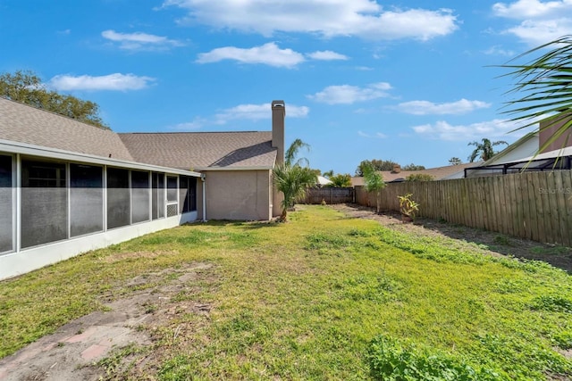 view of yard with a sunroom and a fenced backyard